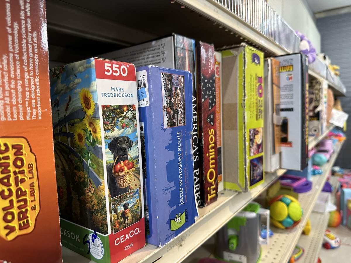 Shelves of puzzles, board games, and toys at the thrift store