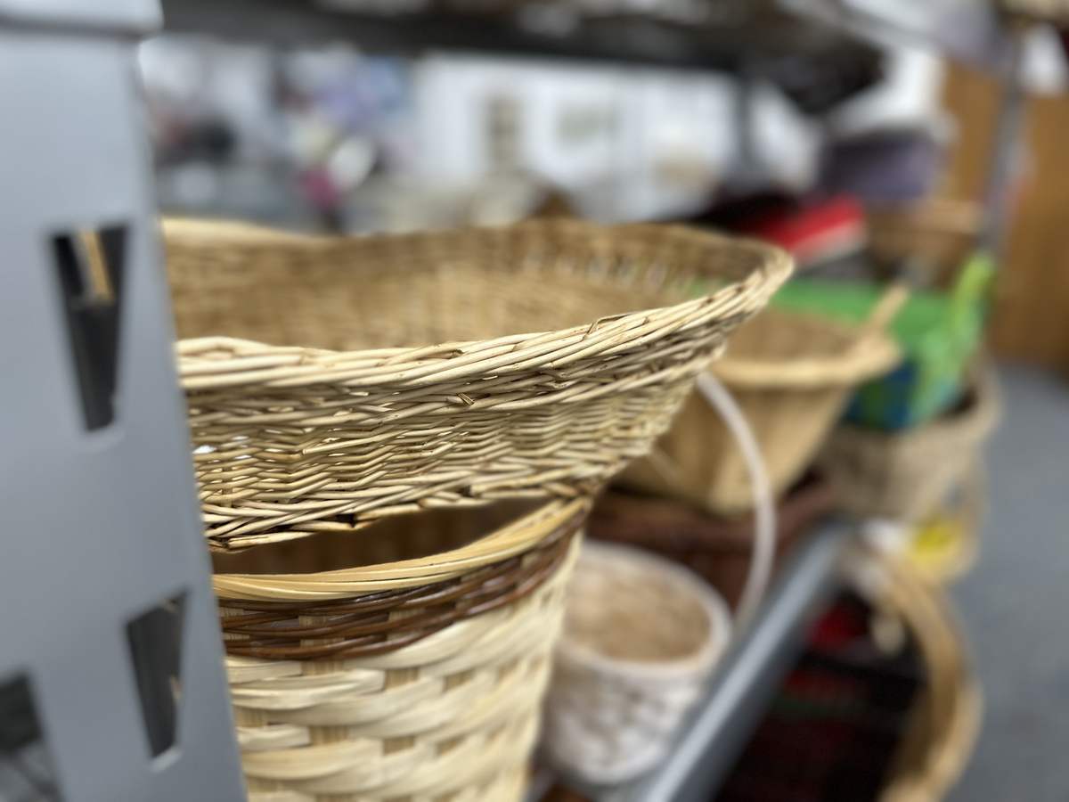 Woven baskets and housewares on thrift store shelves