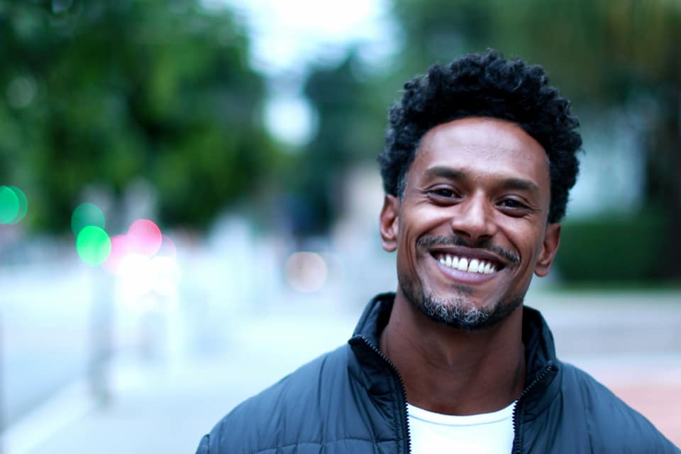 A smiling man outdoors on a city street (photo changed to protect privacy)